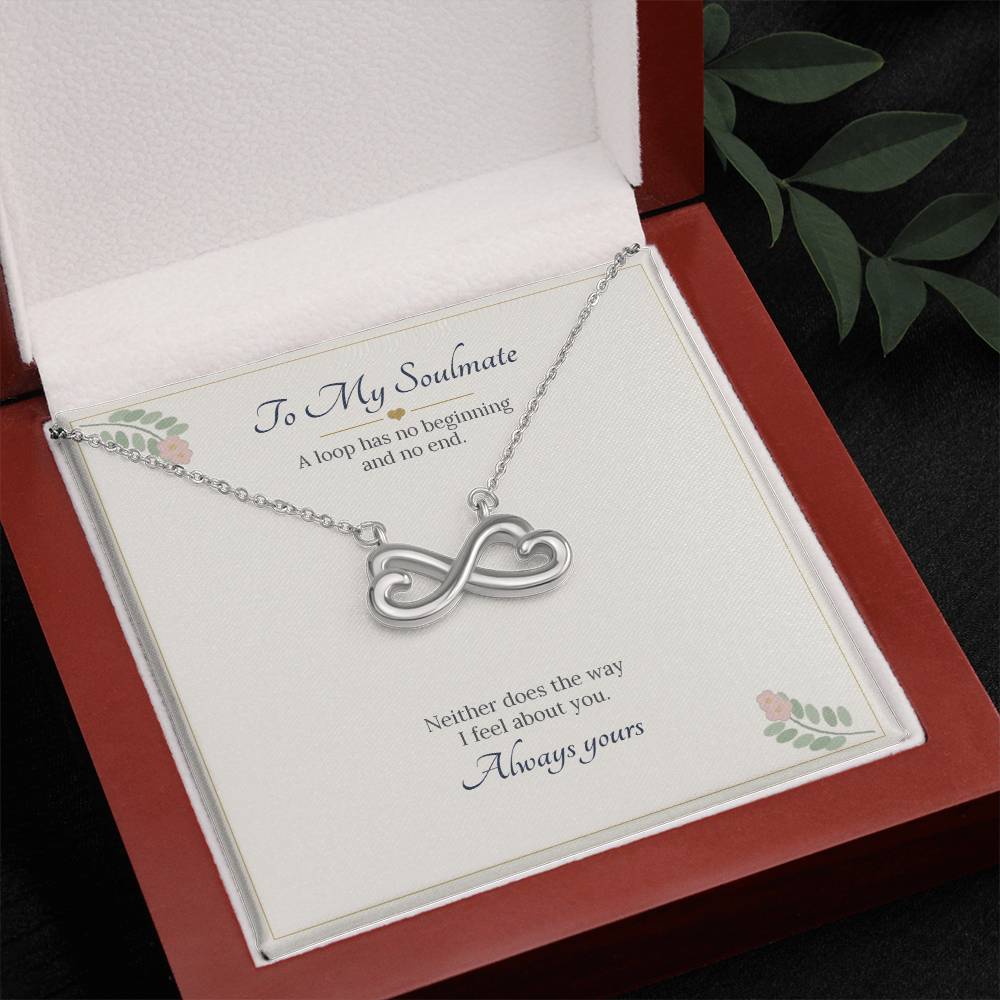 White gold finish infinity heart necklace on the To My Soulmate card in an open wooden luxury box, seen from above with leaves beside it