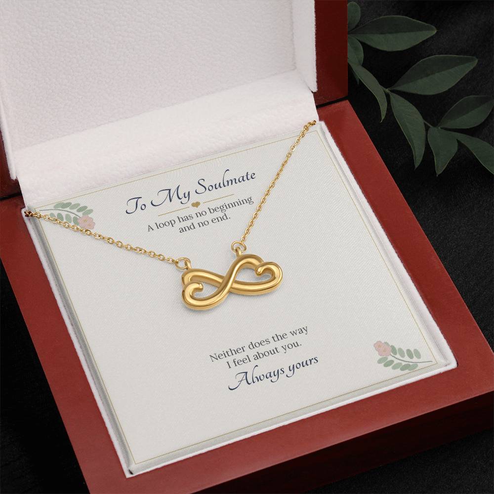 Yellow gold finish infinity heart necklace on the To My Soulmate card in an open wooden luxury box, seen from above with leaves beside it