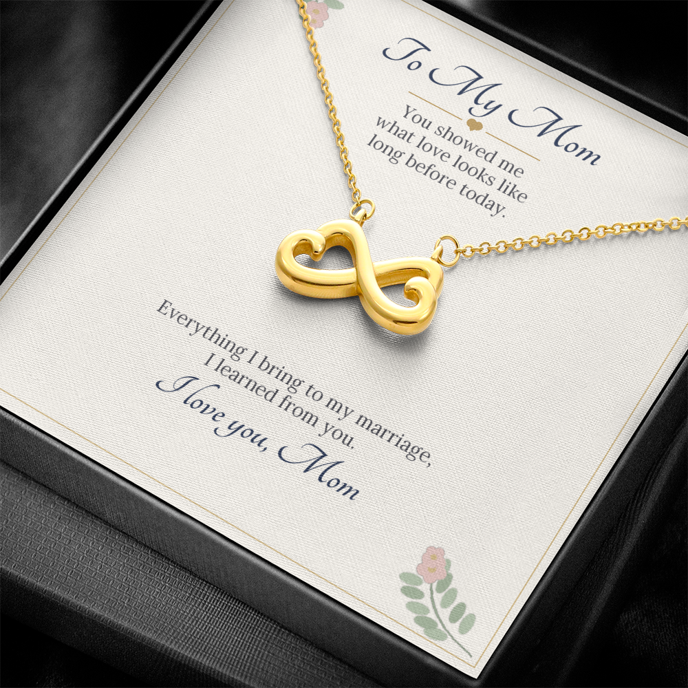 Yellow gold finish infinity heart necklace on the To My Mom wedding card in a black gift box